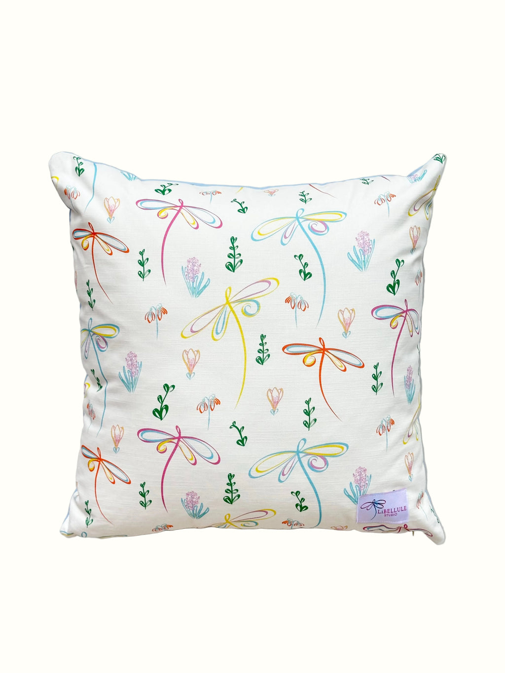 Decorative pillow with colourful floral and dragonfly pattern on a white background