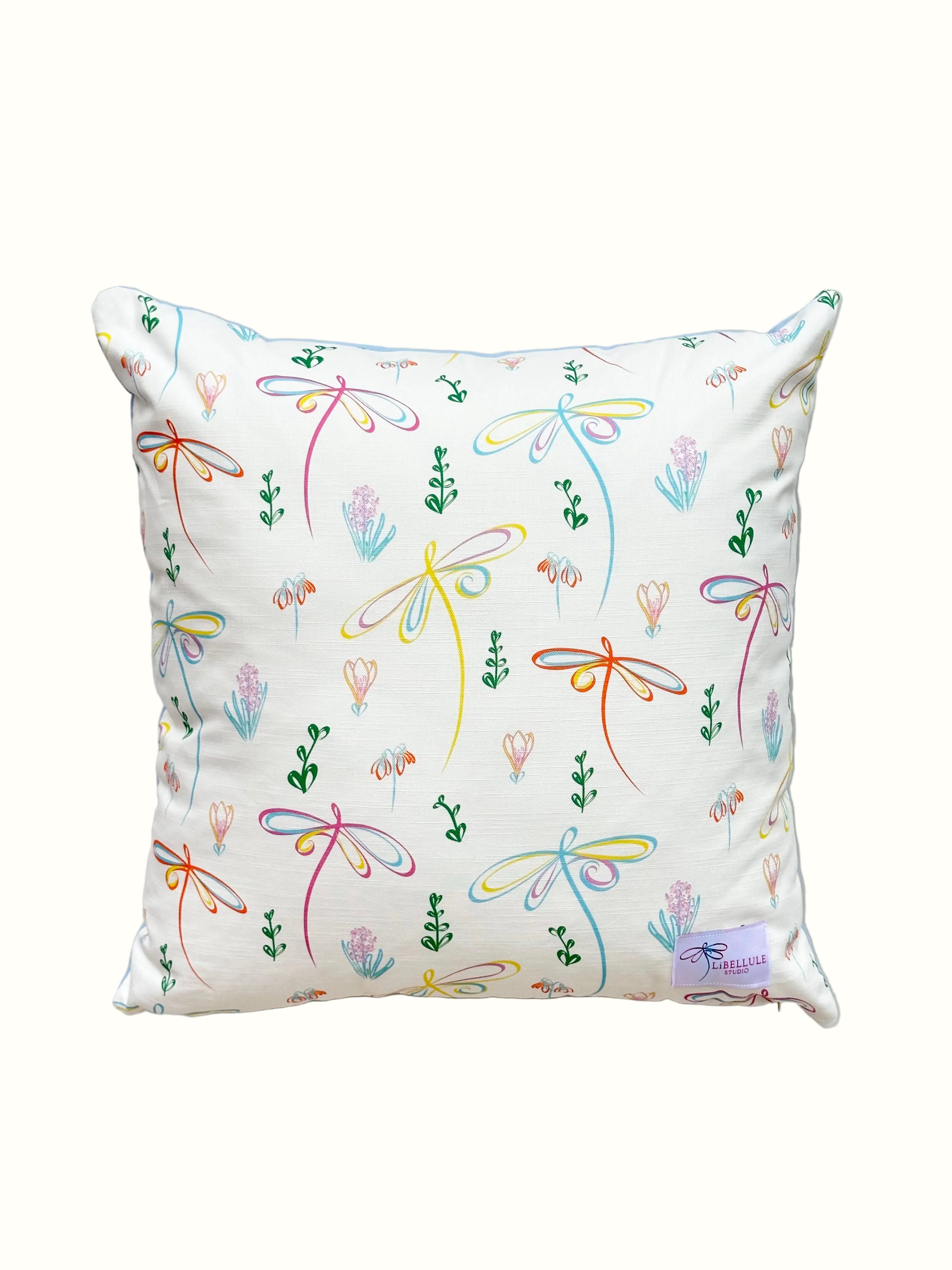 Decorative pillow with colourful floral and dragonfly pattern on a white background